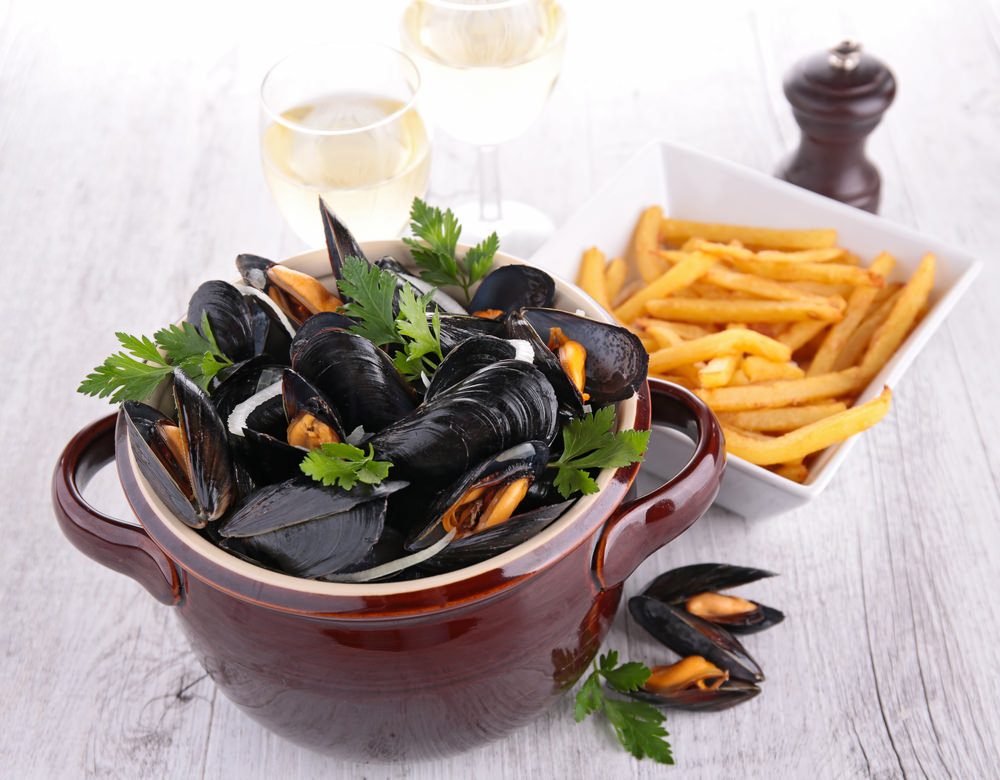 bowl of mussels and french fries in Normandy vacations packages tours